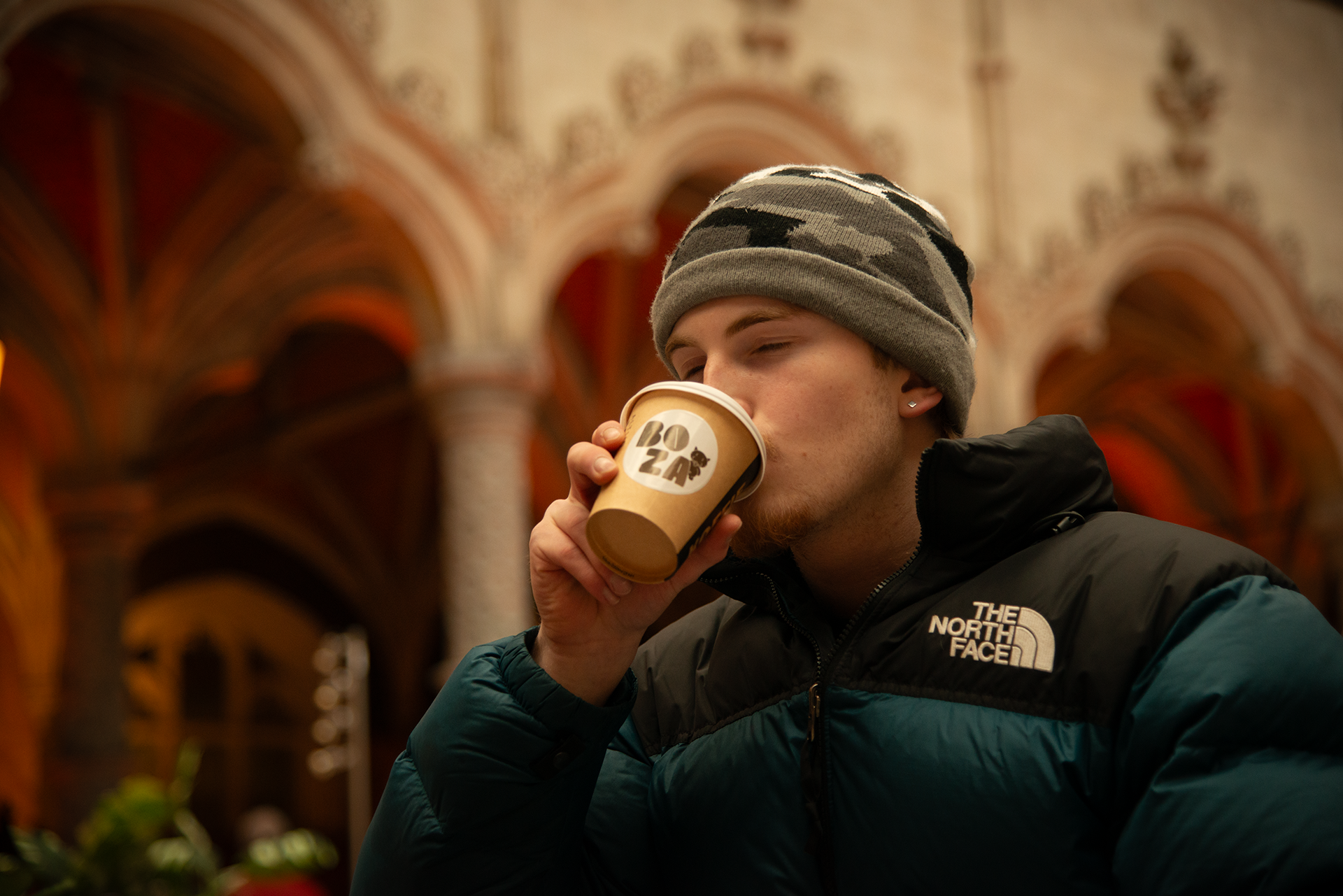 Visitor with coffee at Boza Café pop-up, historic Handelbeurs Antwerp – specialty coffee open Saturday Sunday